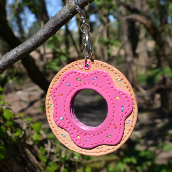 Donut shaped mirror wearable as charm or keychain.